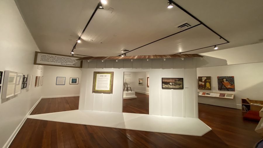 Photo of Andrews Family Legacy Exhibit showing paintings by George and Benny Andrews as well as family photos